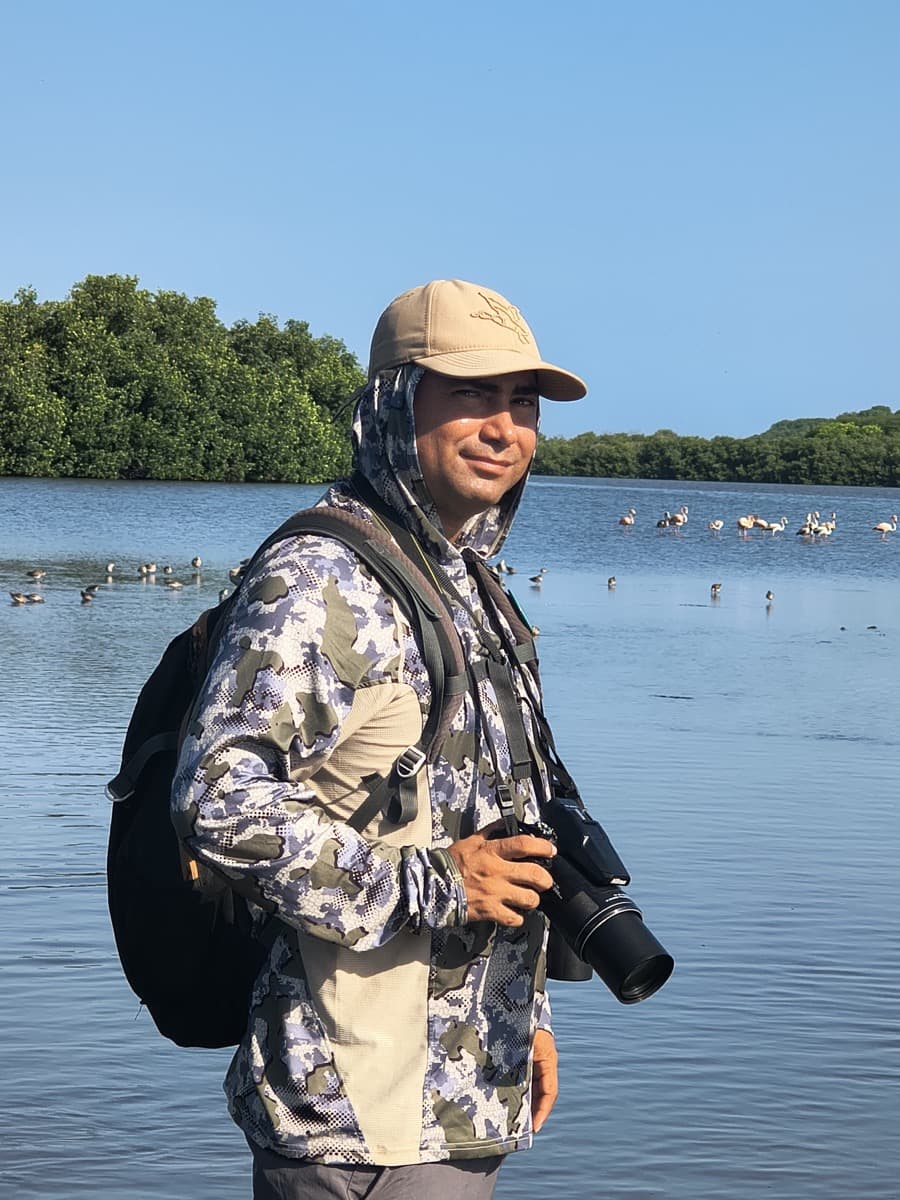 Maicol González Guzmán, guía profesional de naturaleza, con cámara en una laguna del Caribe colombiano
