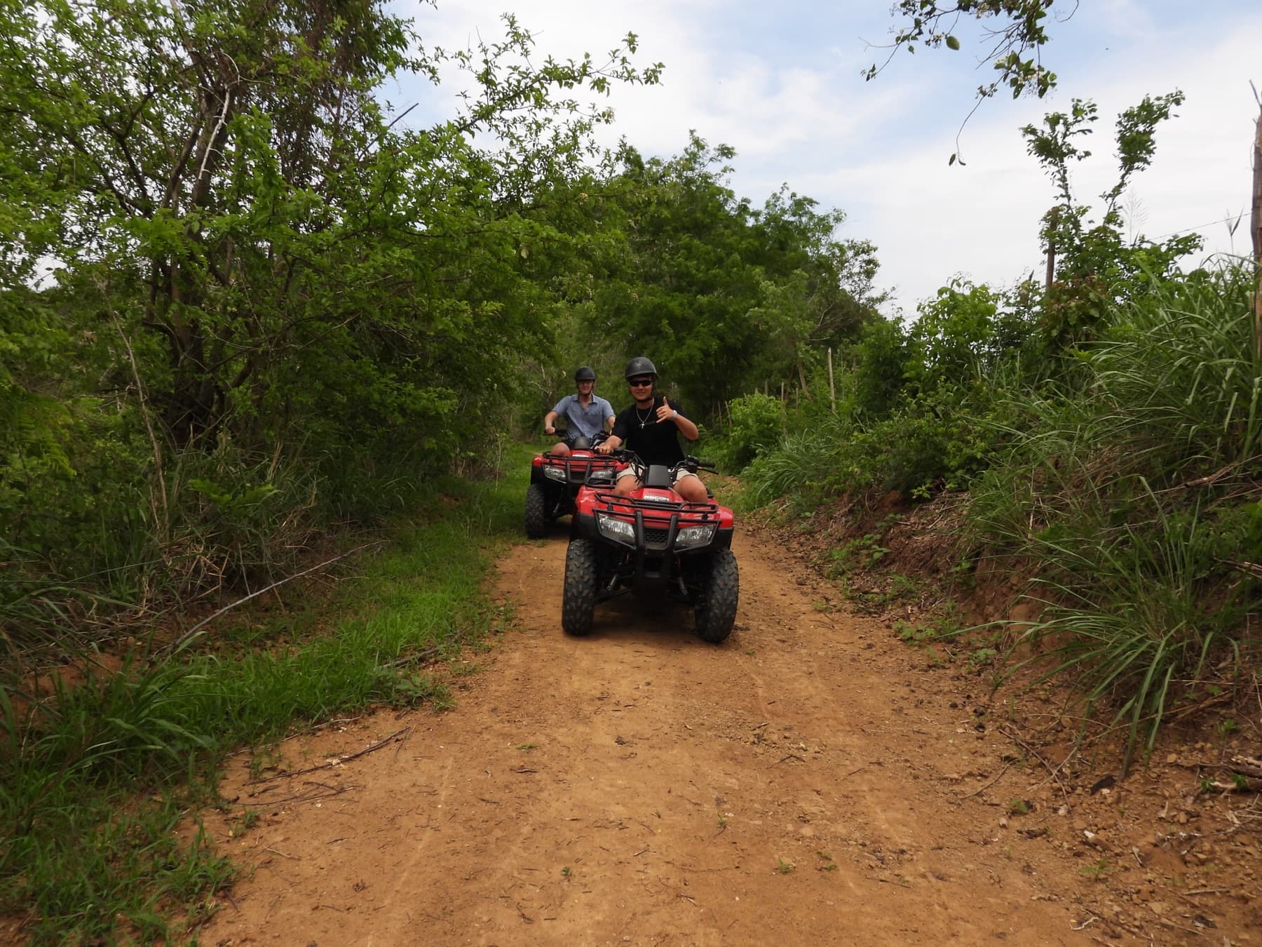 Deux visiteurs en quads rouges patrouillant un sentier ouvert de la réserve