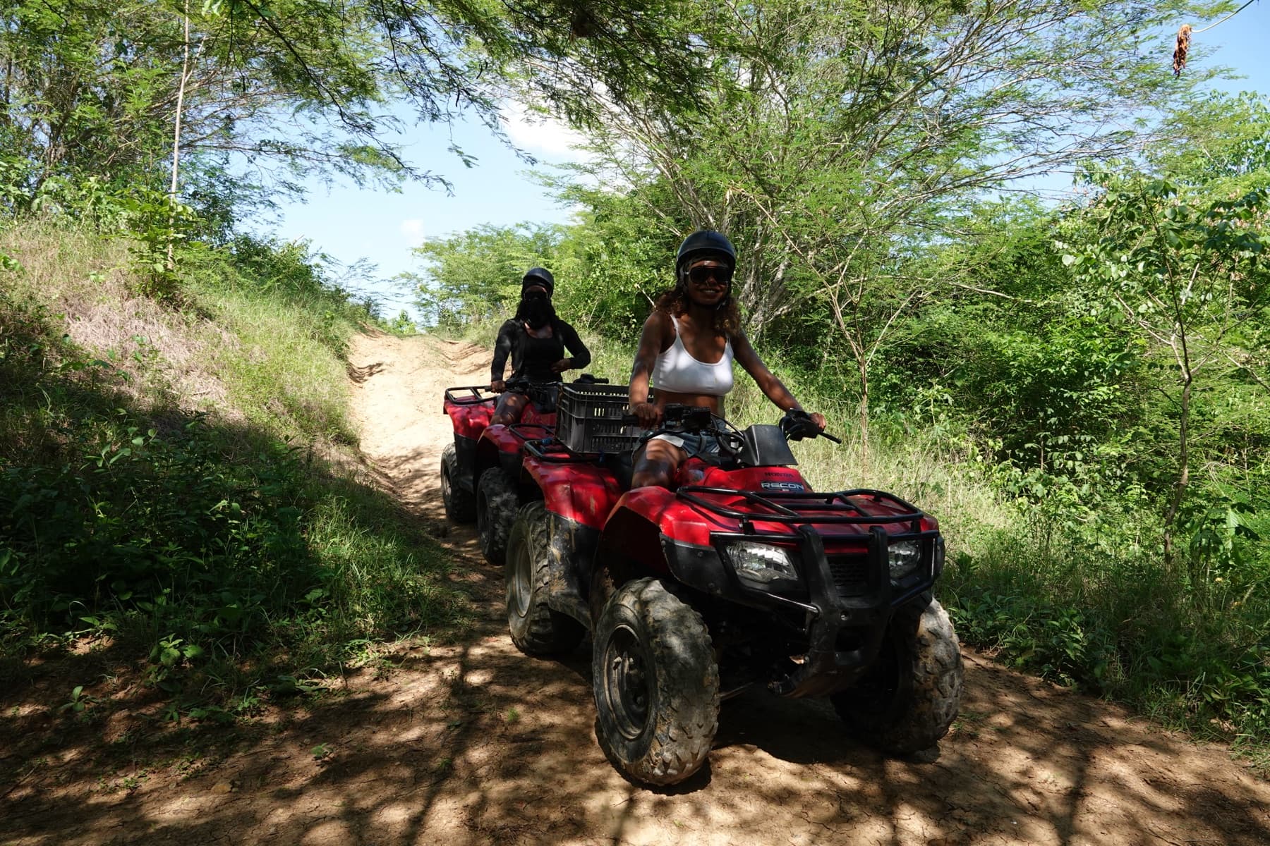 Deux visiteuses en quad descendant un sentier de colline